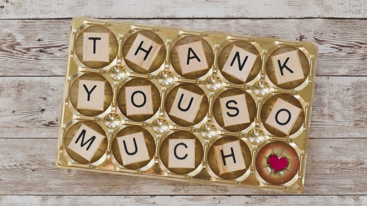 Creative thank you message with wooden block letters in a golden tray. Perfect for appreciation cards.