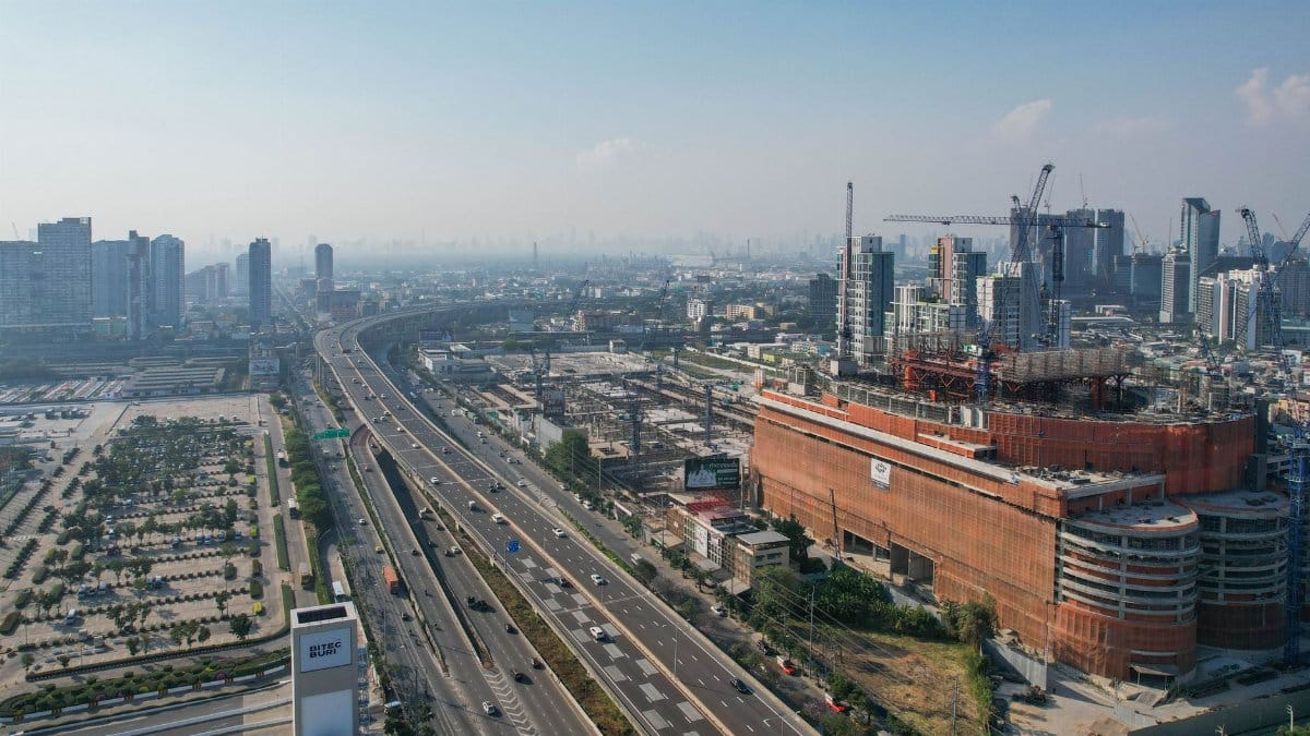 Aerial shot of a busy urban highway amidst skyscrapers and construction work under clear skies.