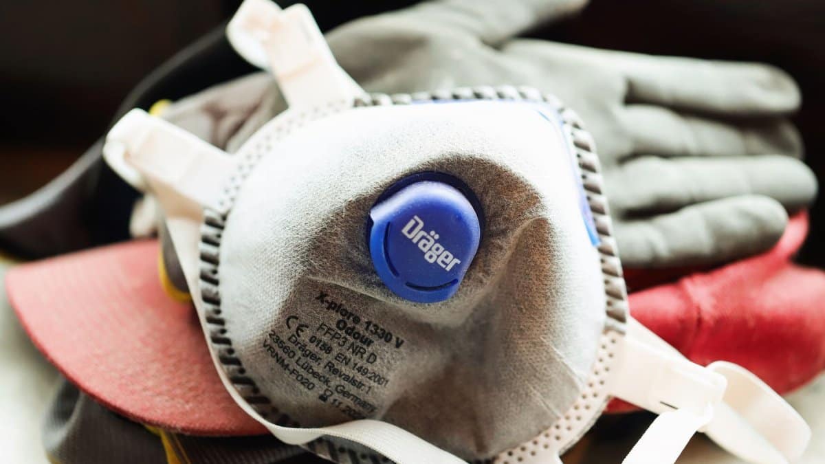 Close-up of a protective mask and work gloves on a building site.