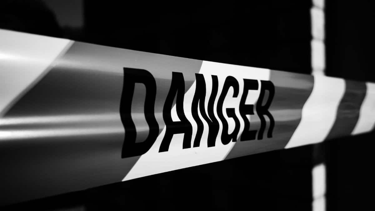 Close-up of a danger tape in black and white, emphasizing caution and warning.