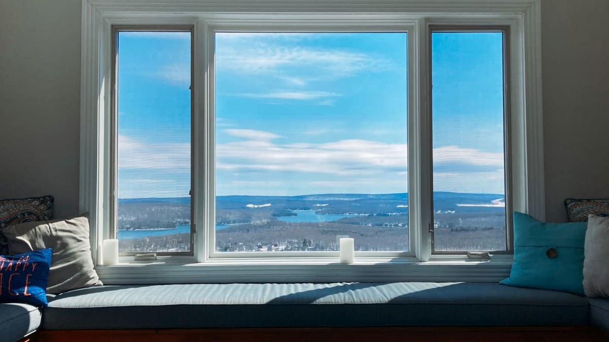 A comfortable indoor window seat overlooking a vast scenic landscape with blue skies in Maryland.