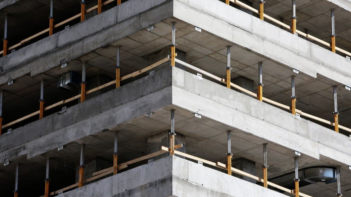 Close-up of an unfinished multi-level concrete building with steel reinforcements.