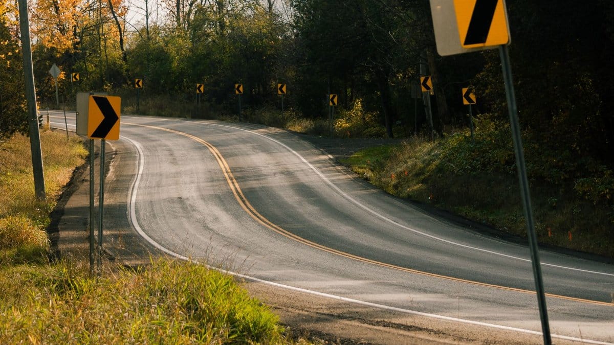 Empty curvy road with visible road signs during fall in Rockwood, Ontario, Canada.
