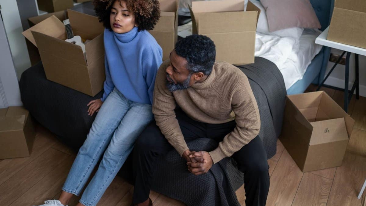 African American couple packing boxes in their bedroom, preparing to move.