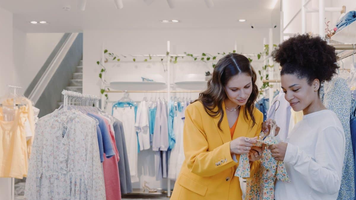 Two women browsing clothes in a stylish, modern boutique.
