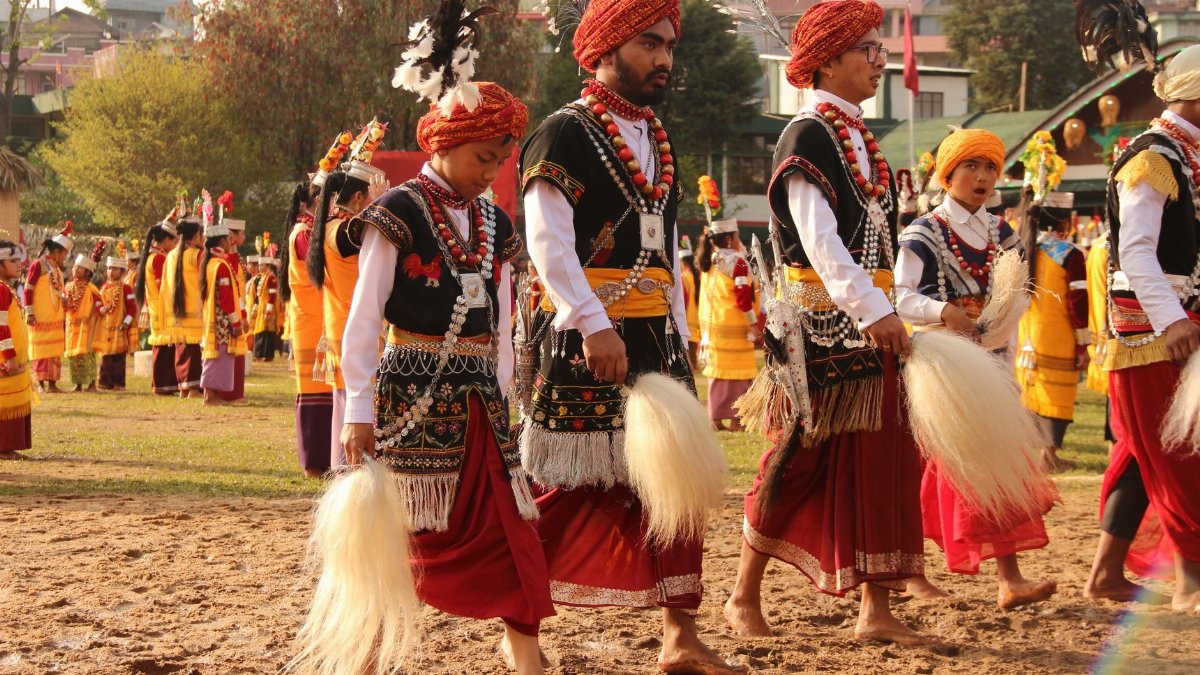 Vibrant Indian festival with men and women in traditional attire celebrating outdoors.