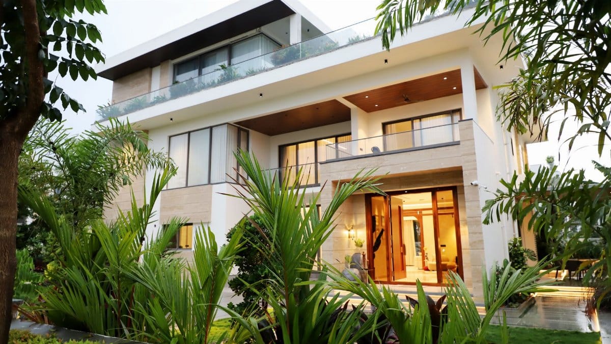 A modern luxury villa surrounded by lush greenery, showcasing contemporary architectural design.