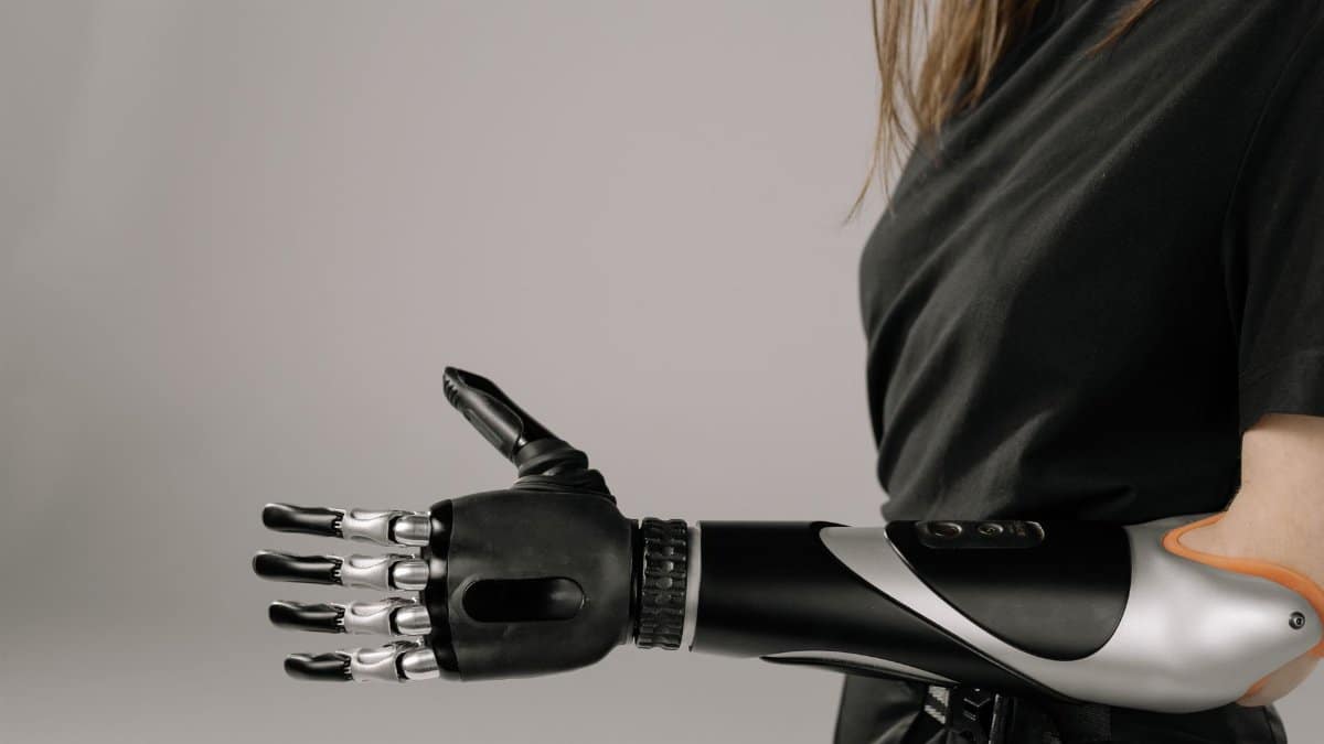 Close-up of a woman wearing a sleek, modern prosthetic arm. Studio shot emphasizes technology and innovation.