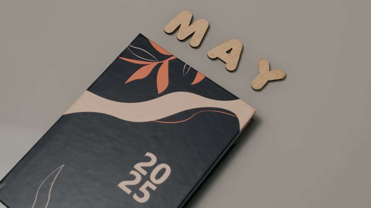 A modern and stylish 2025 planner next to wooden letters spelling 'MAY'. Perfect for organization.