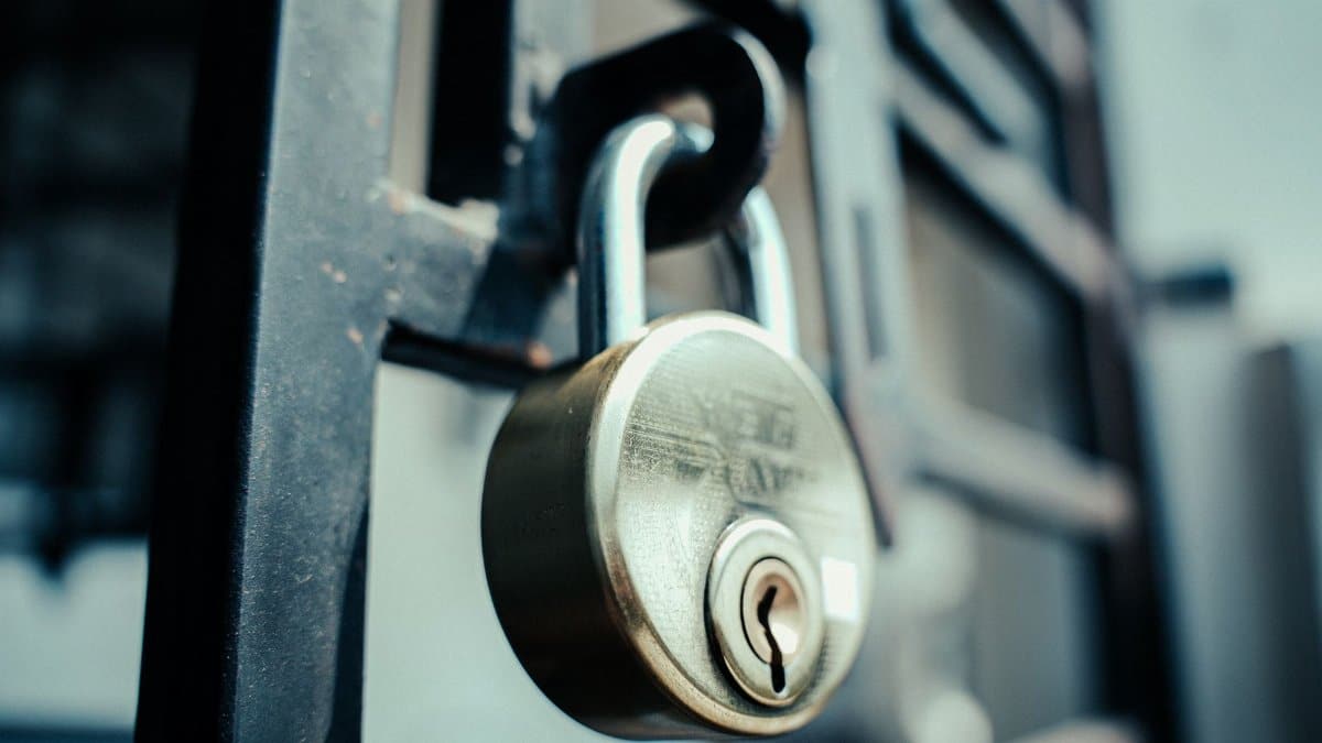 Steel padlock securely fastened on a gate, symbolizing security and protection.