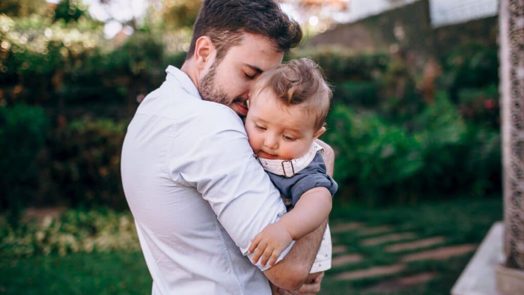 Heartwarming outdoor scene of a father lovingly holding his baby.