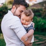 Heartwarming outdoor scene of a father lovingly holding his baby.
