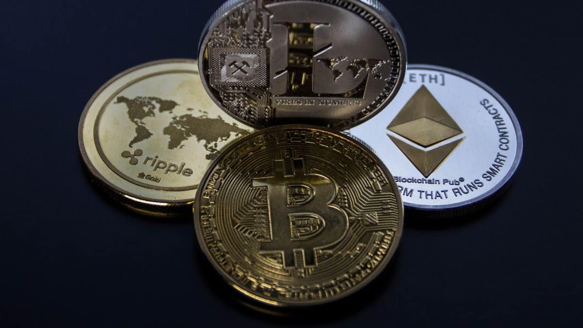Detailed photo showcasing bitcoin, ethereum, litecoin, and ripple coins representing digital currency.