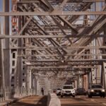 View of a steel bridge filled with cars, showcasing urban infrastructure.
