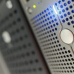 Focused detail of a modern server rack with blue LED indicators in a data center.
