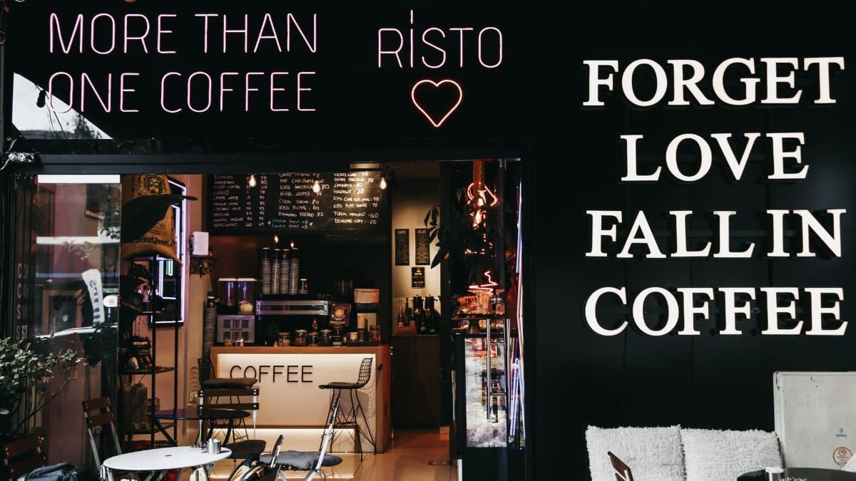Trendy café interior with neon signs and cozy coffee setup, perfect for urban relaxation.