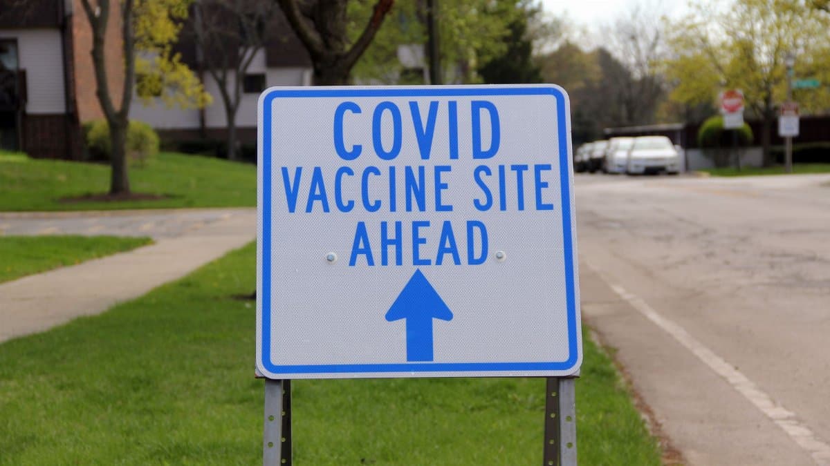 Sign directing to a COVID vaccine site, located outdoors on a street in Deerfield, IL.