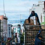 Urban scene in Chinatown with workers loading cardboard, city street view.