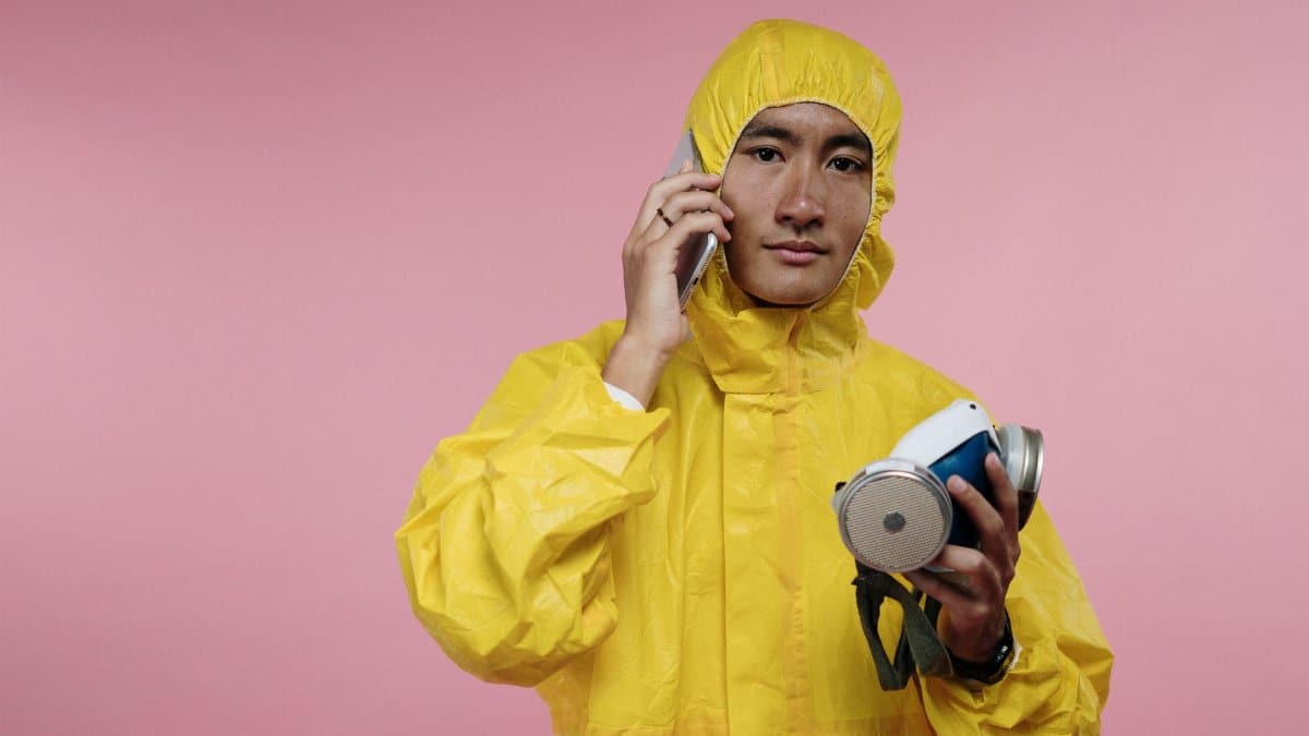 Individual in a yellow hazmat suit making a phone call, emphasizing safety and communication.
