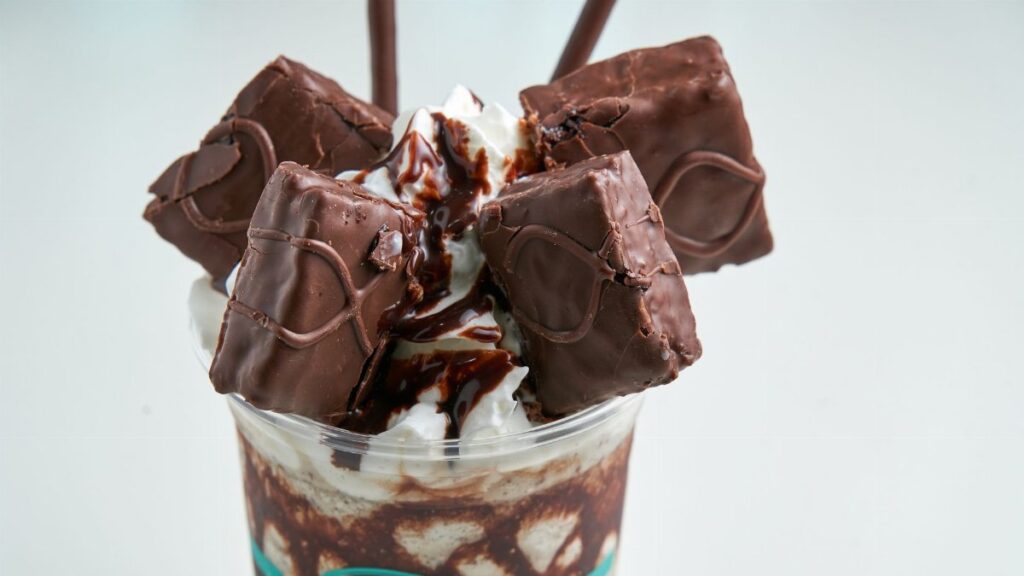 Sumptuous chocolate dessert topped with rich chocolate pieces and cream for a sweet indulgence.
