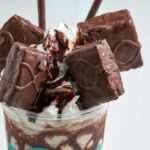 Sumptuous chocolate dessert topped with rich chocolate pieces and cream for a sweet indulgence.