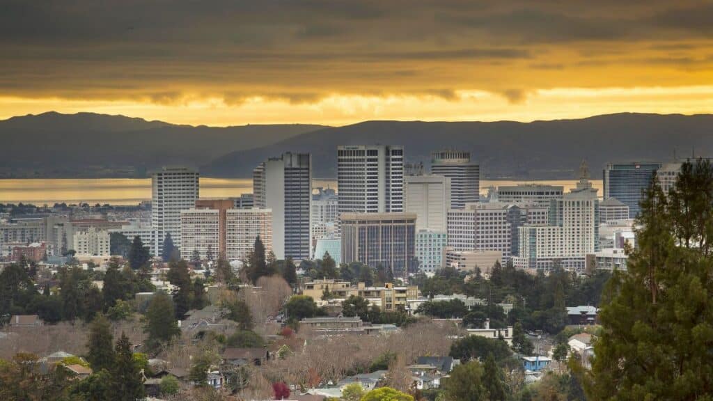 Skyline of Oakland, California at sunset with dramatic skies.