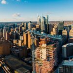 From above of modern district in city with high rise buildings under blue sky in sunny day