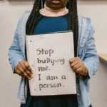 African American girl with empowering anti-bullying message in school setting.