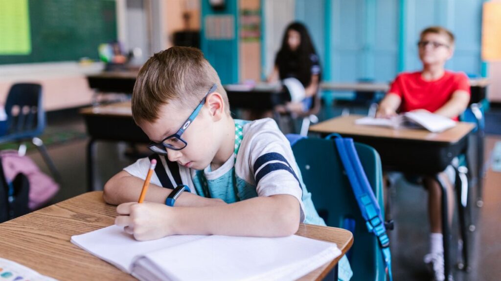 Young students engaged in writing activities during a classroom session.