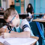 Young students engaged in writing activities during a classroom session.