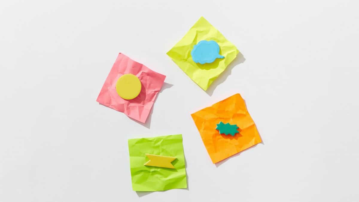 Bright crumpled sticky notes with shapes flatlay on a white background.