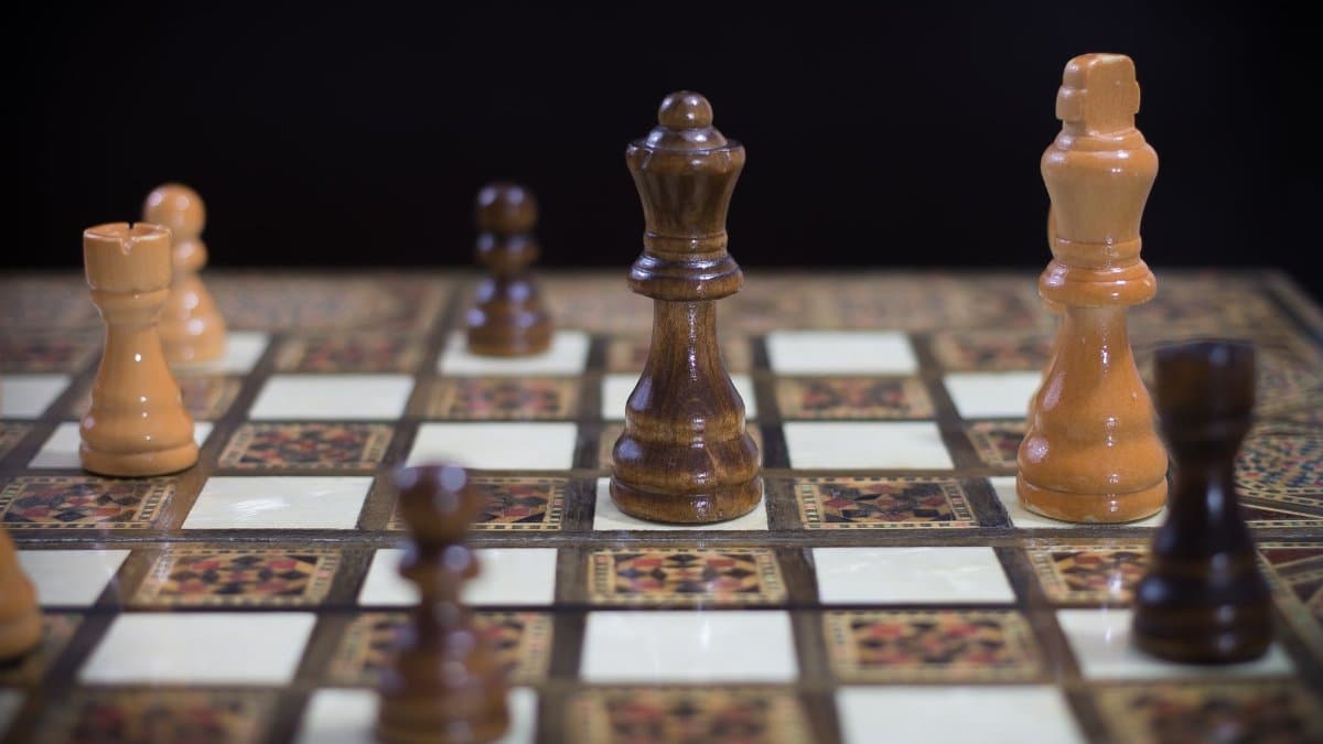 Close-up of a detailed chessboard with elegant wooden pieces, highlighting strategy and focus.