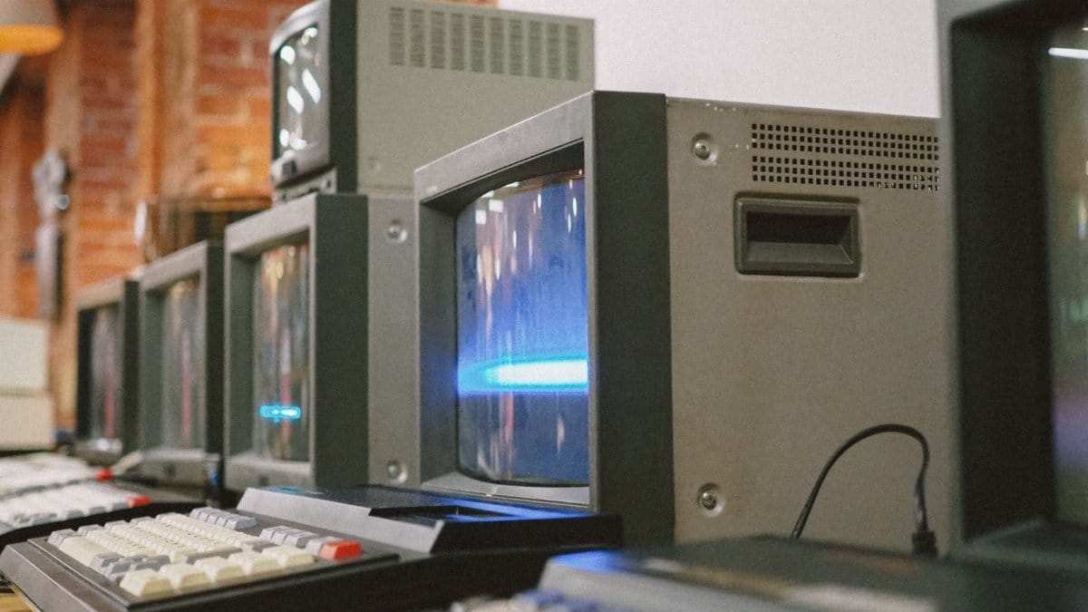 Row of vintage CRT computer monitors showcasing classic technology indoors.