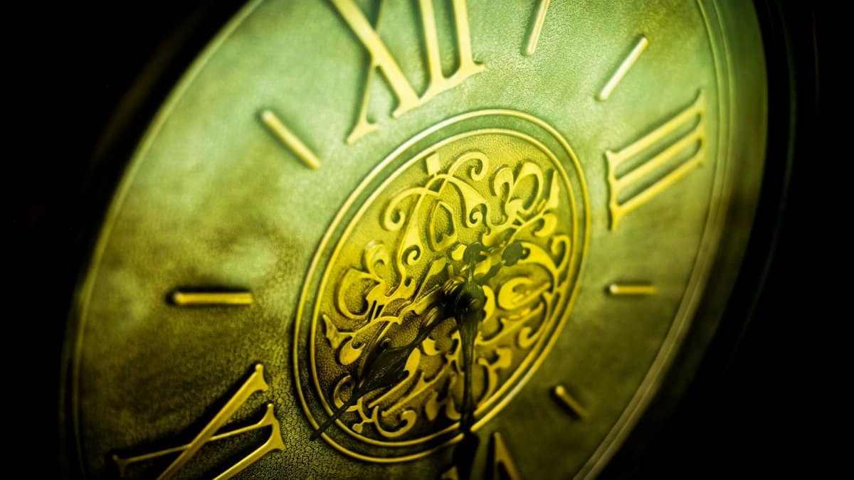 An elegant close-up of an antique clock face showcasing intricate design and Roman numerals.