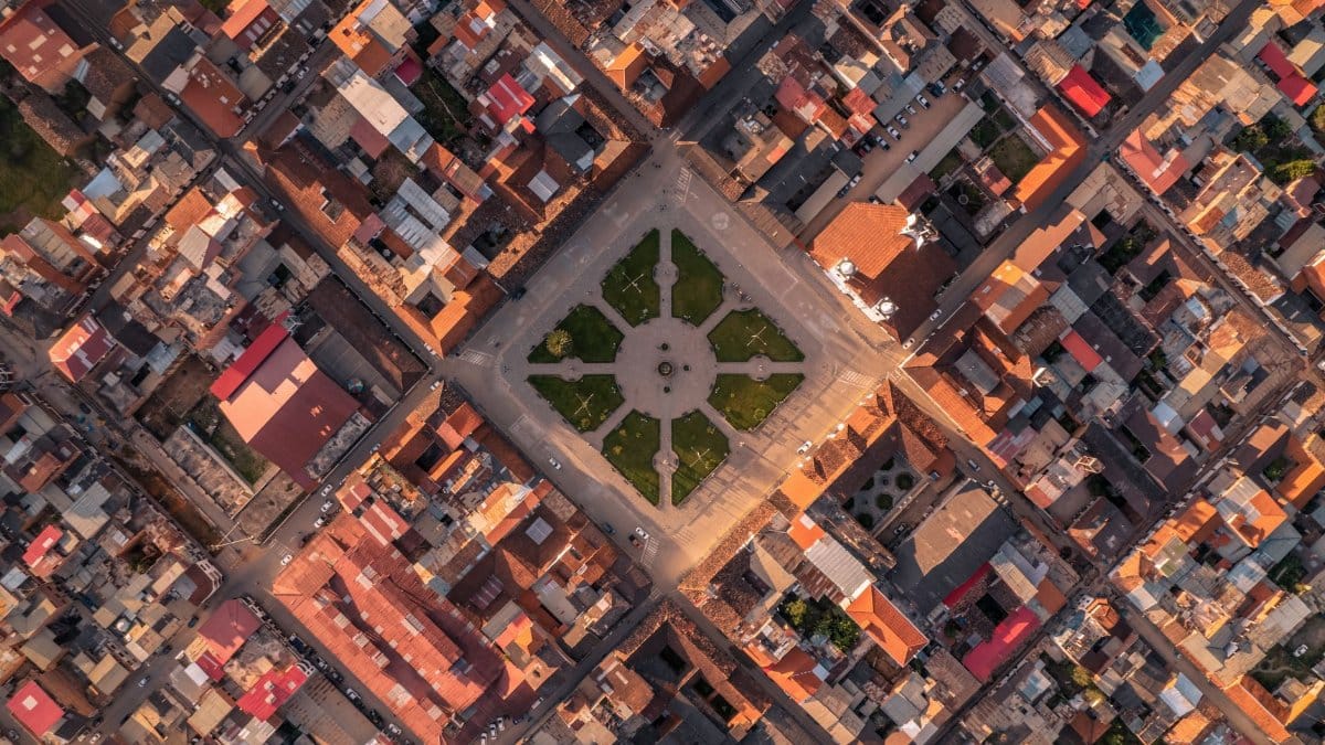 Drone shot of the historic city center of Chachapoyas, Peru, showcasing a vibrant urban grid layout and central park.