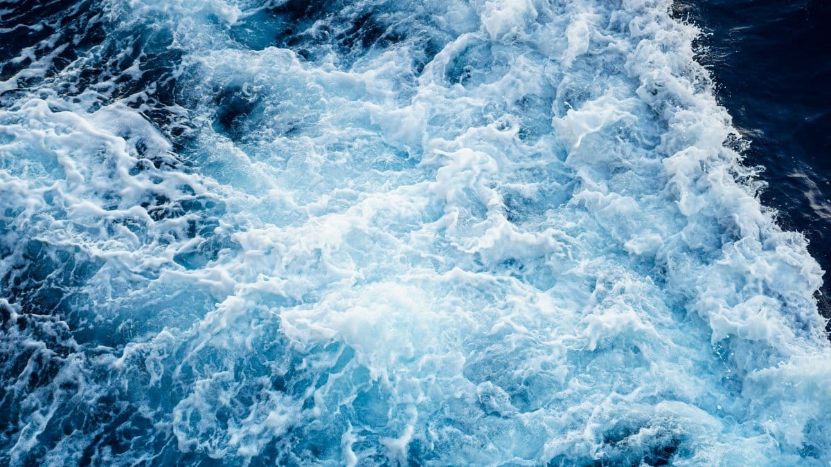 Aerial view of powerful ocean waves crashing, showcasing natural water patterns and textures.