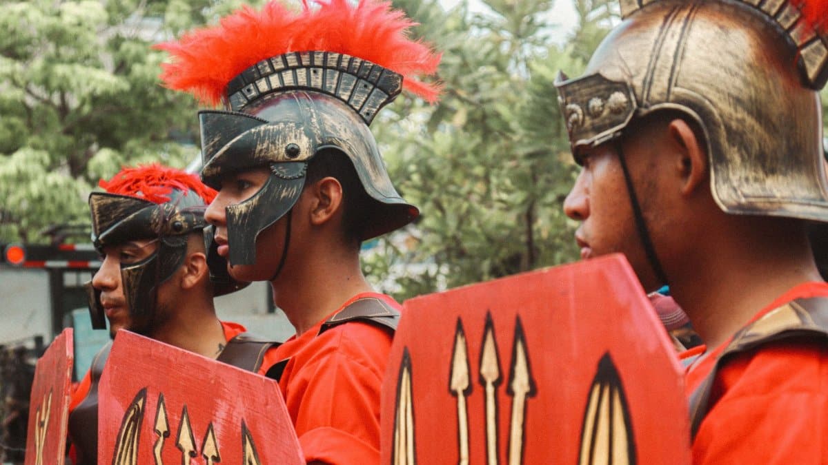 Men dressed as Roman warriors in a lively outdoor parade.