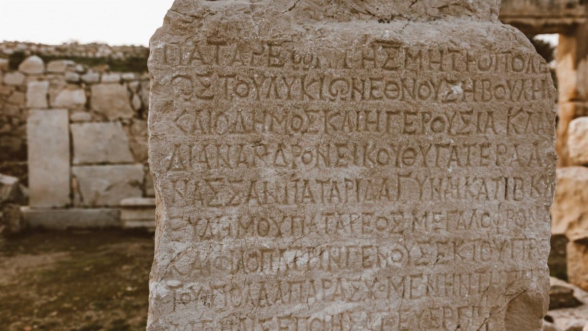 Close-up of an ancient Greek inscribed stone in an archaeological site.