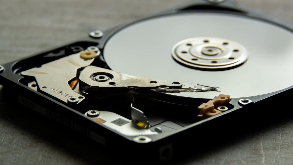 Detailed view of an open hard drive, showcasing the disk platter and actuator arm.