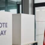 Voting booth setup with American flag, symbolizing election day.