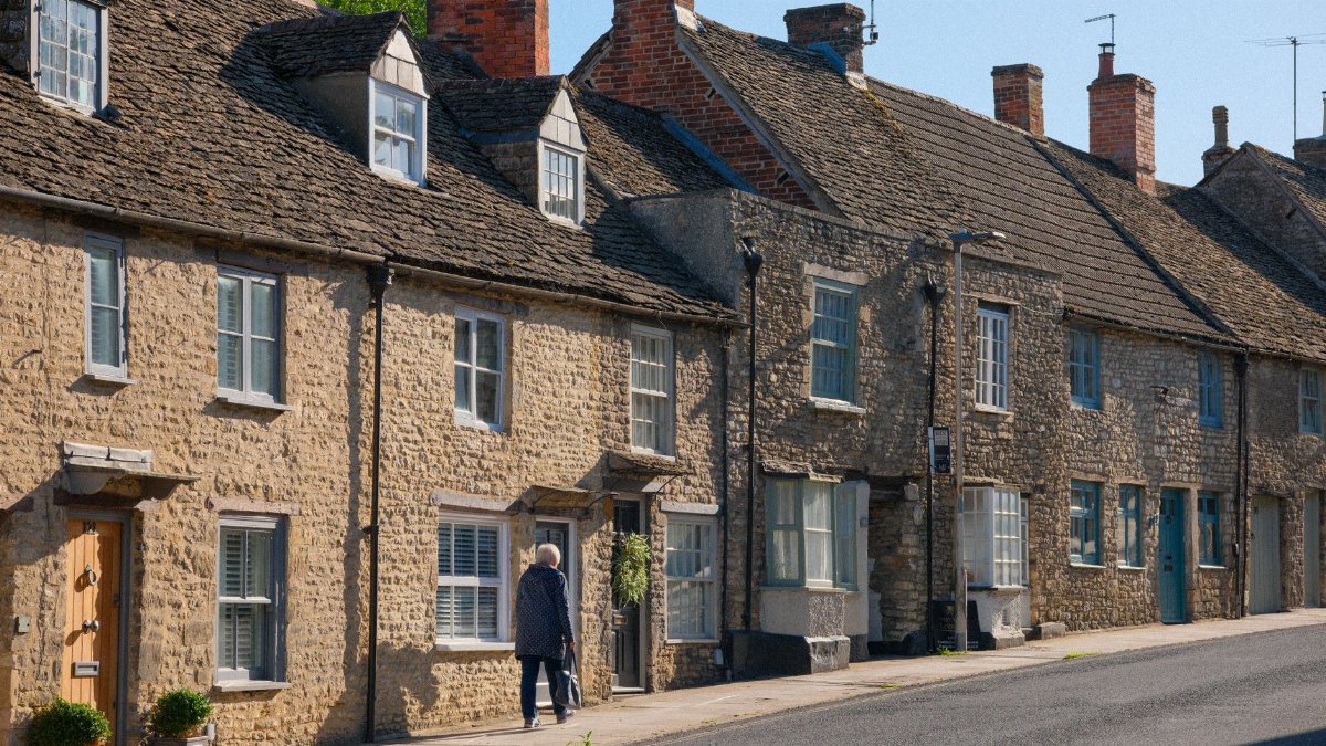Picturesque stone cottages on a sunny day in Malmesbury, England, showcasing classic rural architecture.