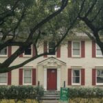 Classic colonial house with red shutters and trees in Houston, Texas, available for lease.