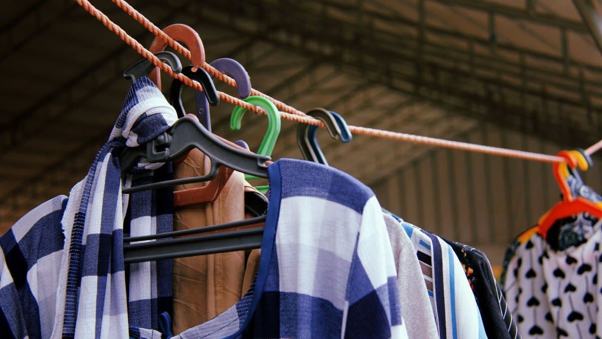 Close-up of vibrant clothes hanging on a line, showcasing various patterns and colors on hangers.