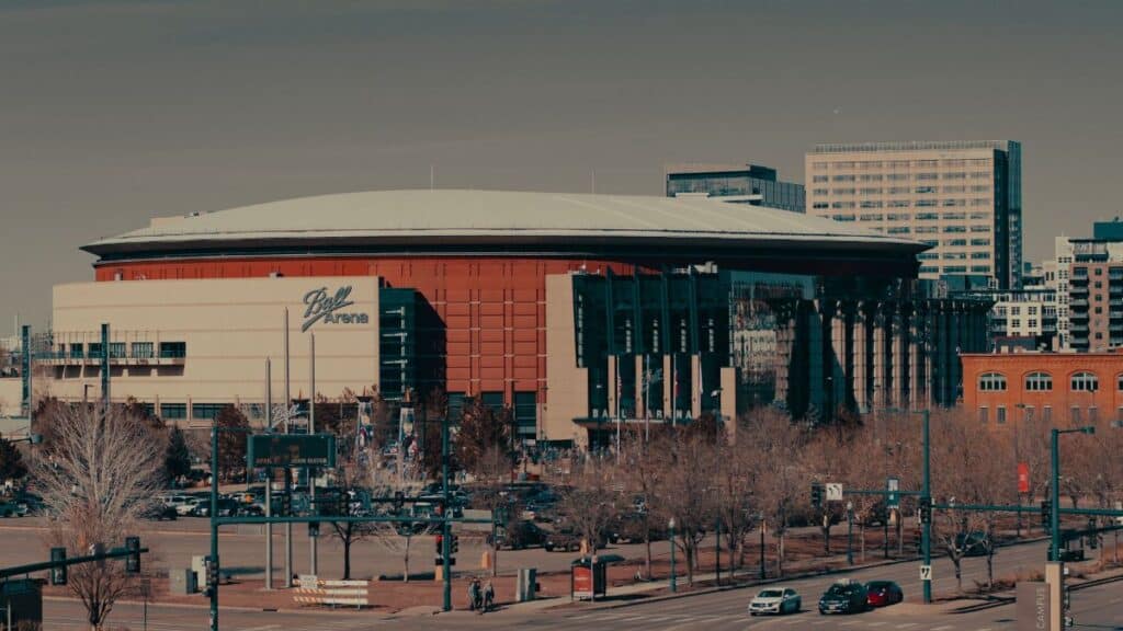 A daylight view of Ball Arena amidst Denver's urban landscape, highlighting its architectural design.
