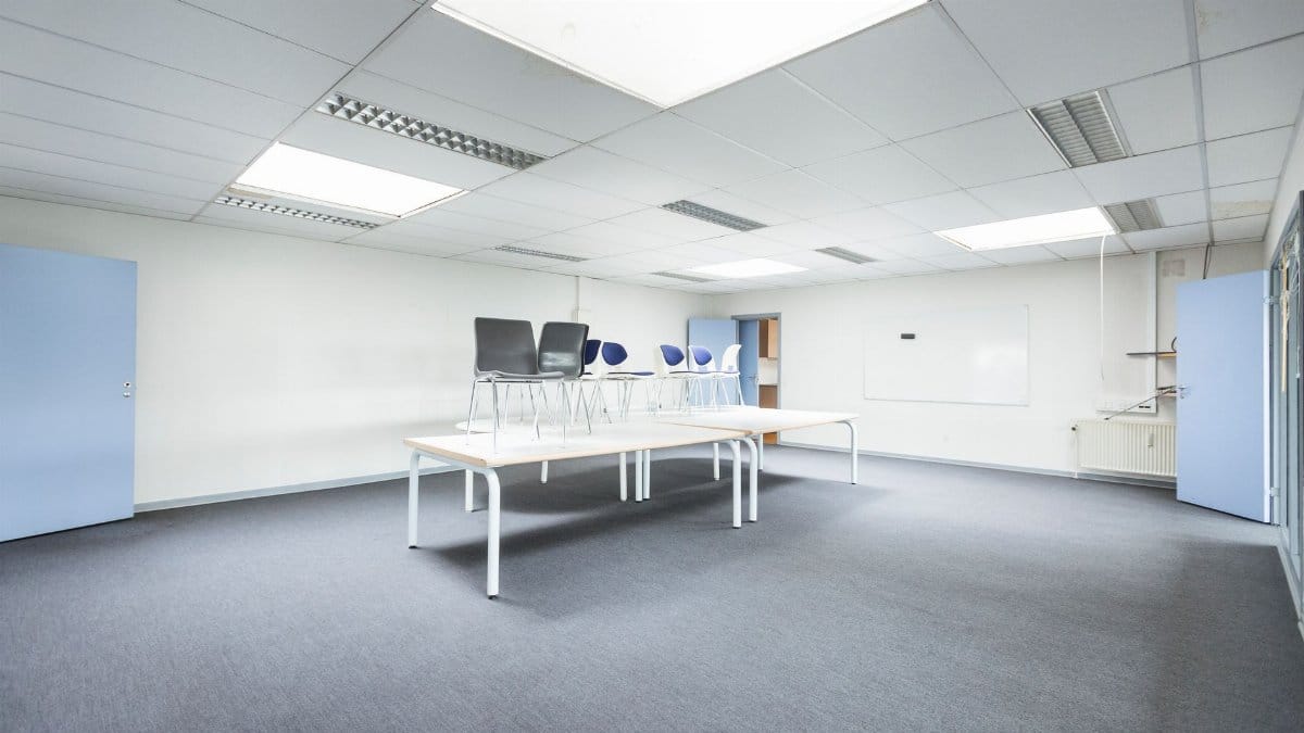 Spacious minimalist office with tables and chairs arranged creatively.