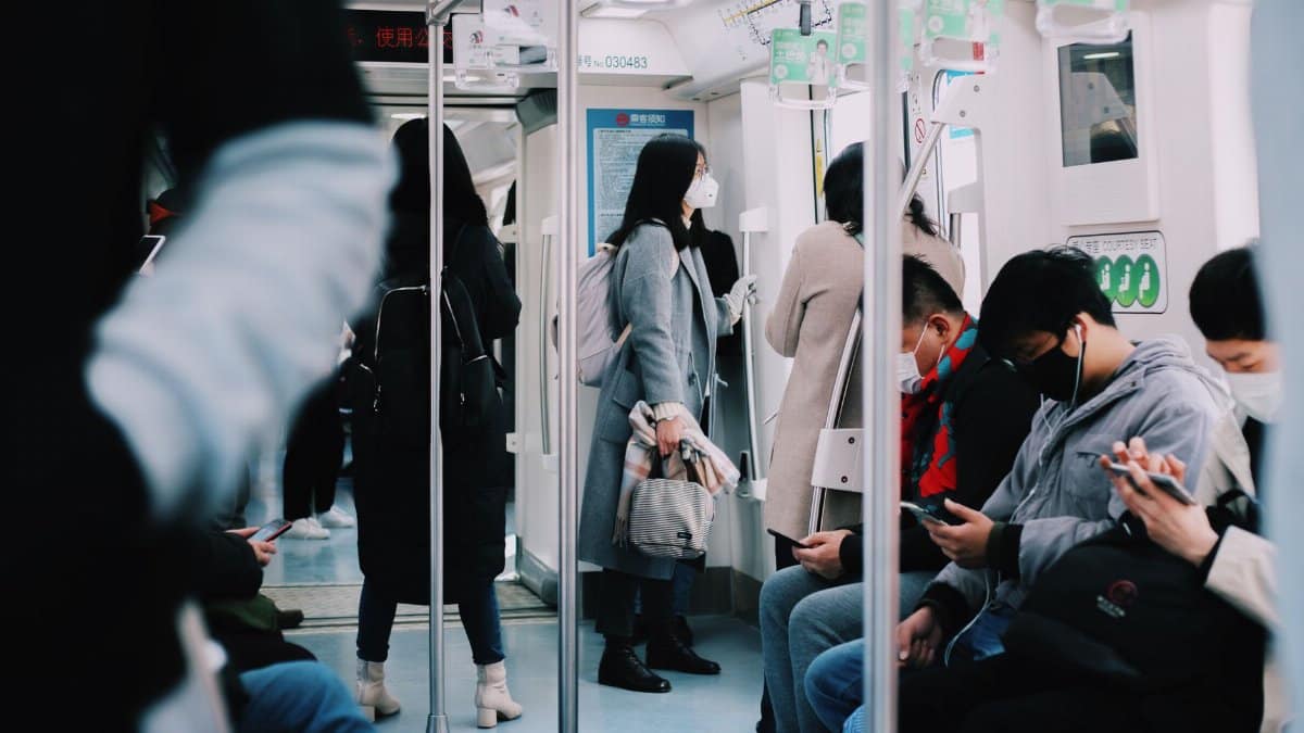 People wearing masks on Shanghai subway, reflecting urban life during pandemic times.