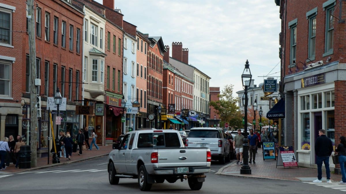 Vibrant street view of downtown Portsmouth, New Hampshire, with historic architecture and people walking.