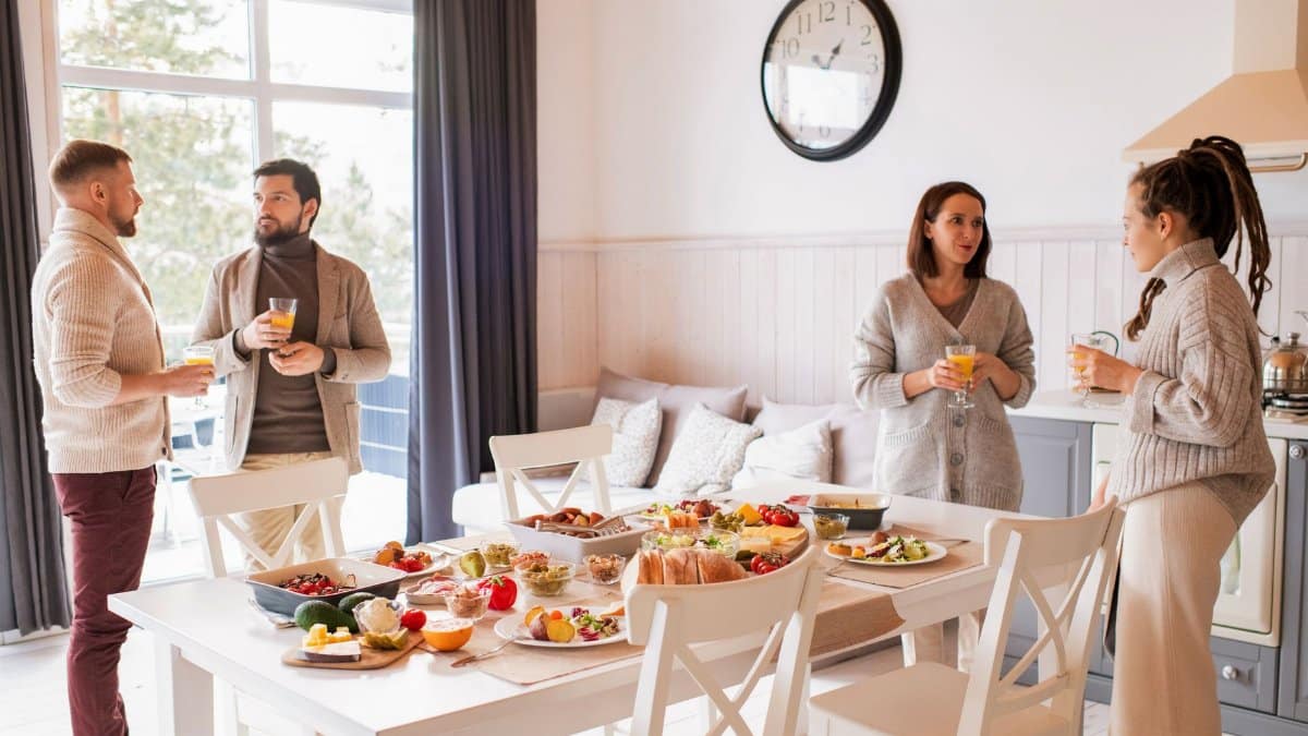 Friends enjoying a cozy brunch indoors with a full spread of delicious food and drinks.