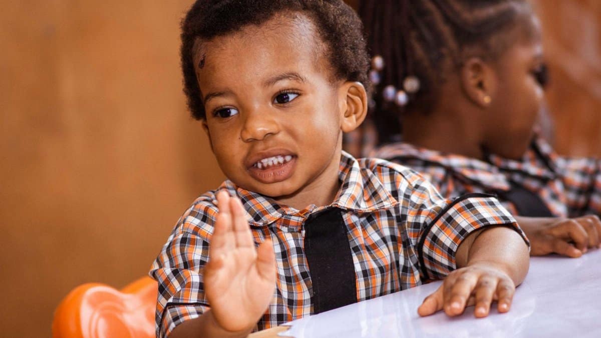 Two young children enjoy a fun interactive session in their classroom, expressing joy and engagement.