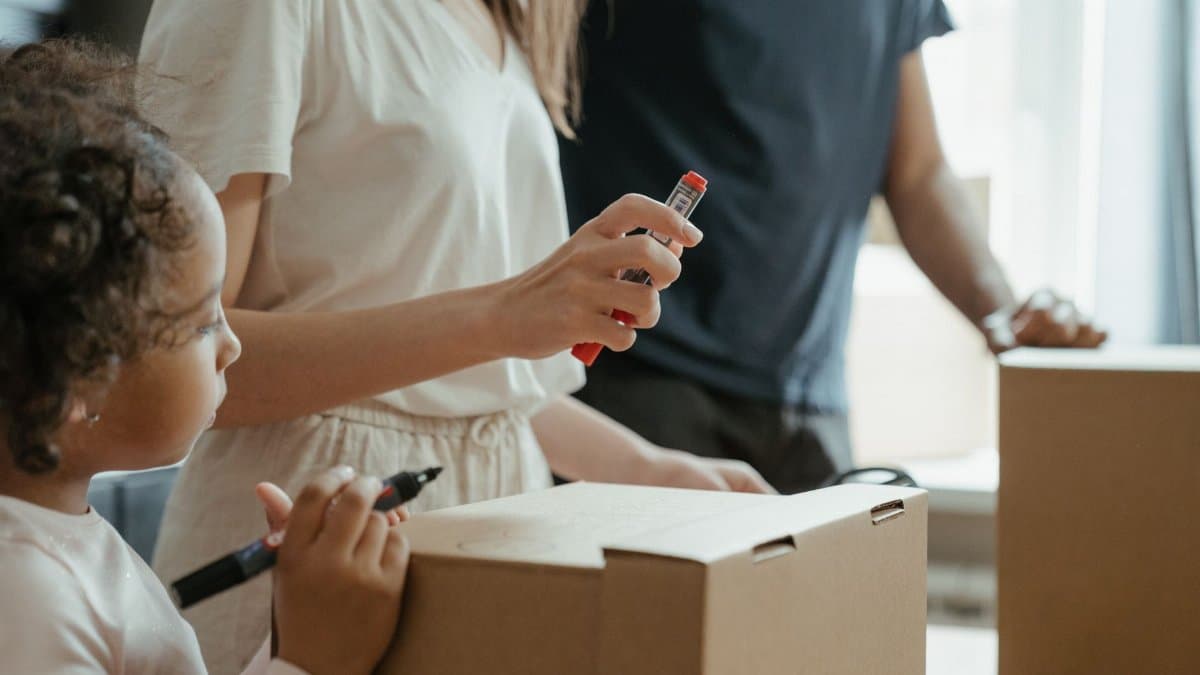 A family engaging in domestic life while moving into a new home, unpacking boxes.